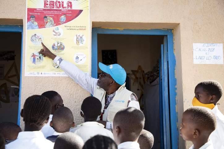 En man som pekar på en poster med texten ebola