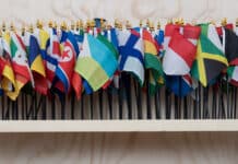 En rad med flaggor flankerad av FNs flagga