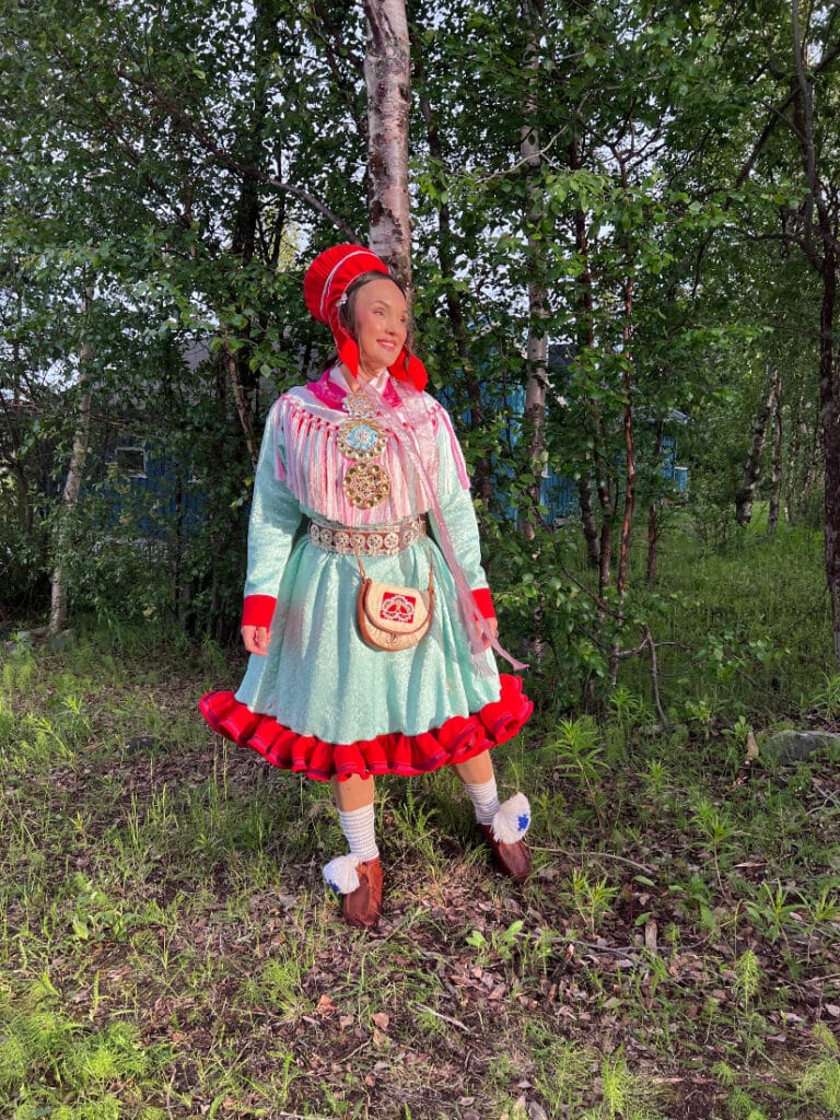 En kvinna i traditionell samisk klädsel sommartid